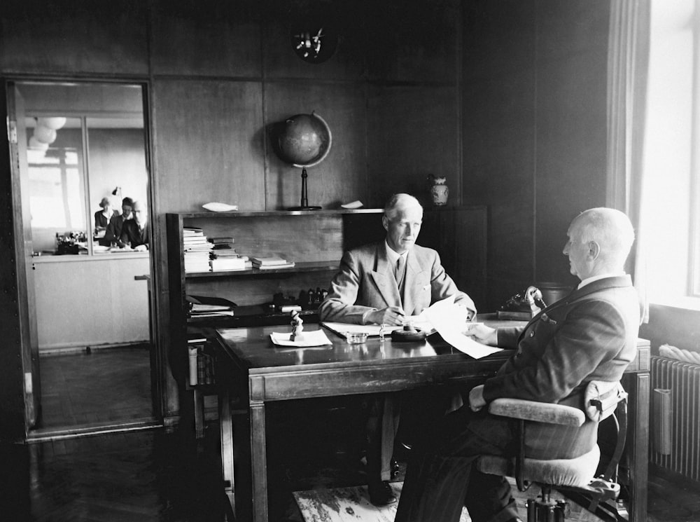 a man sitting at a desk in front of a window