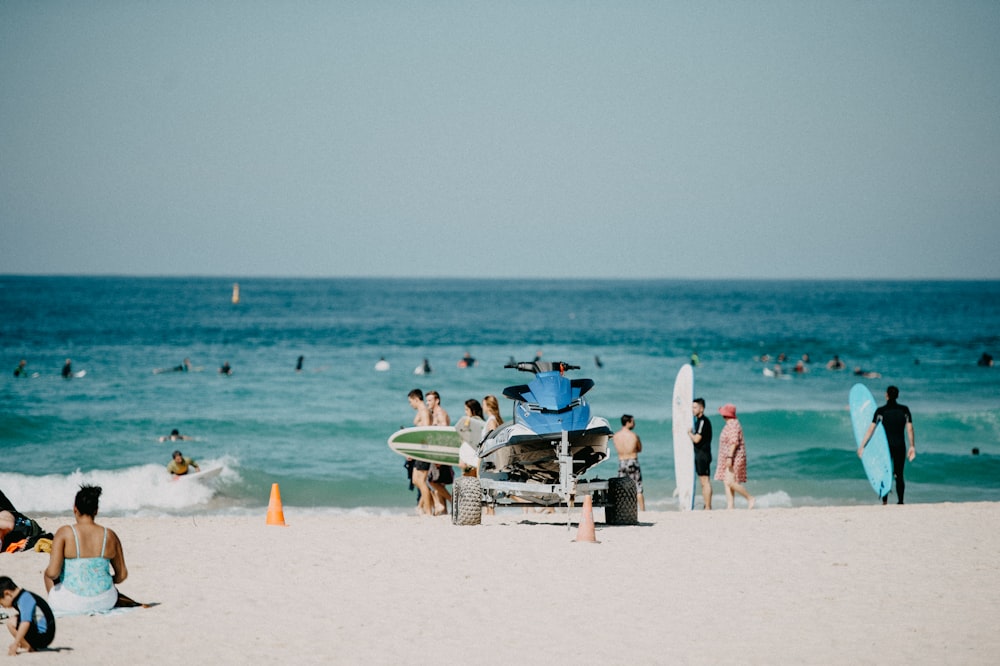 a group of people standing on top of a sandy beach