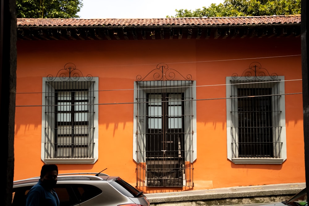 a car parked in front of an orange building