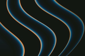 Dark, smooth, wavy lines with a glowing edge move diagonally across a black background. The lines have a blue hue with a hint of orange outlining.
