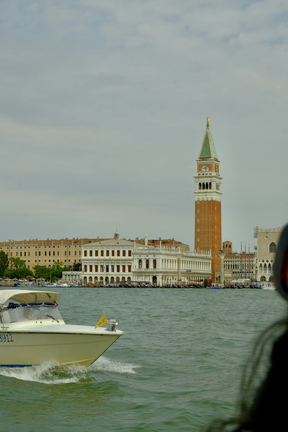 a boat in a body of water with a clock tower in the background