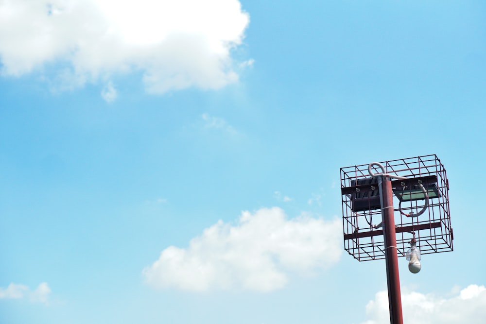 a tall red pole with a clock on top of it