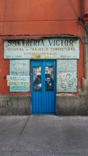 a red building with a blue door and graffiti on it