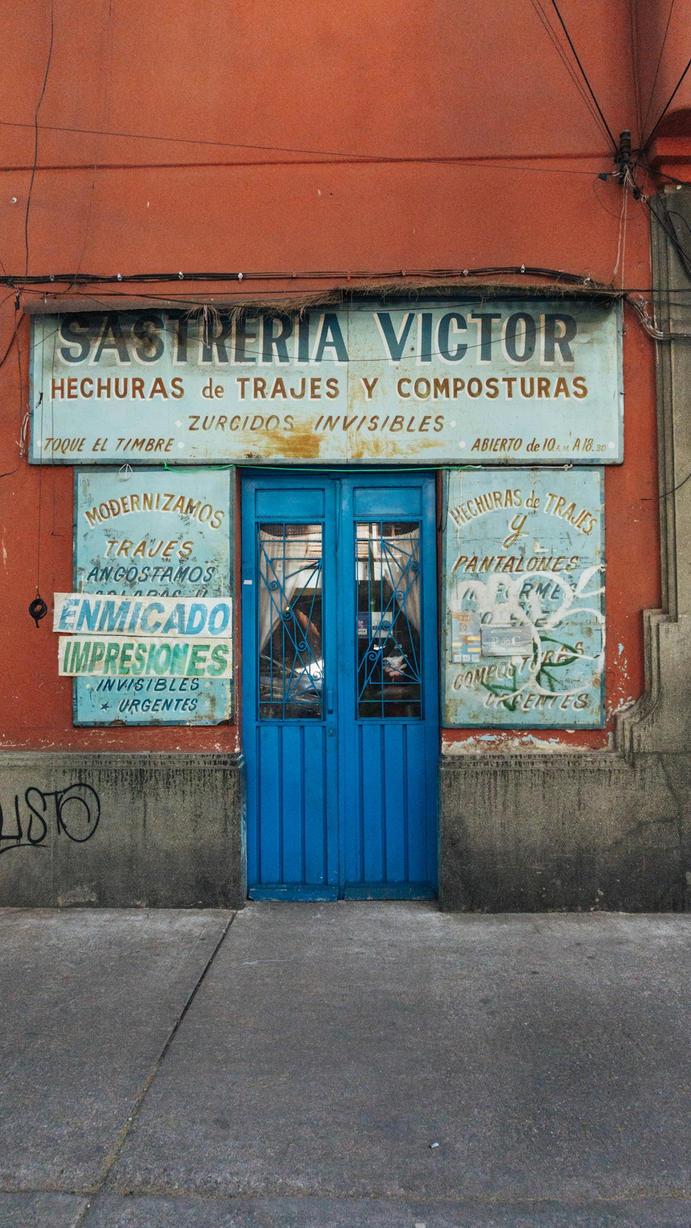 a red building with a blue door and graffiti on it