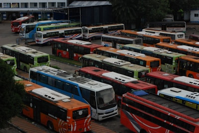 A fleet of well-maintained buses lined up at a transportation hub.