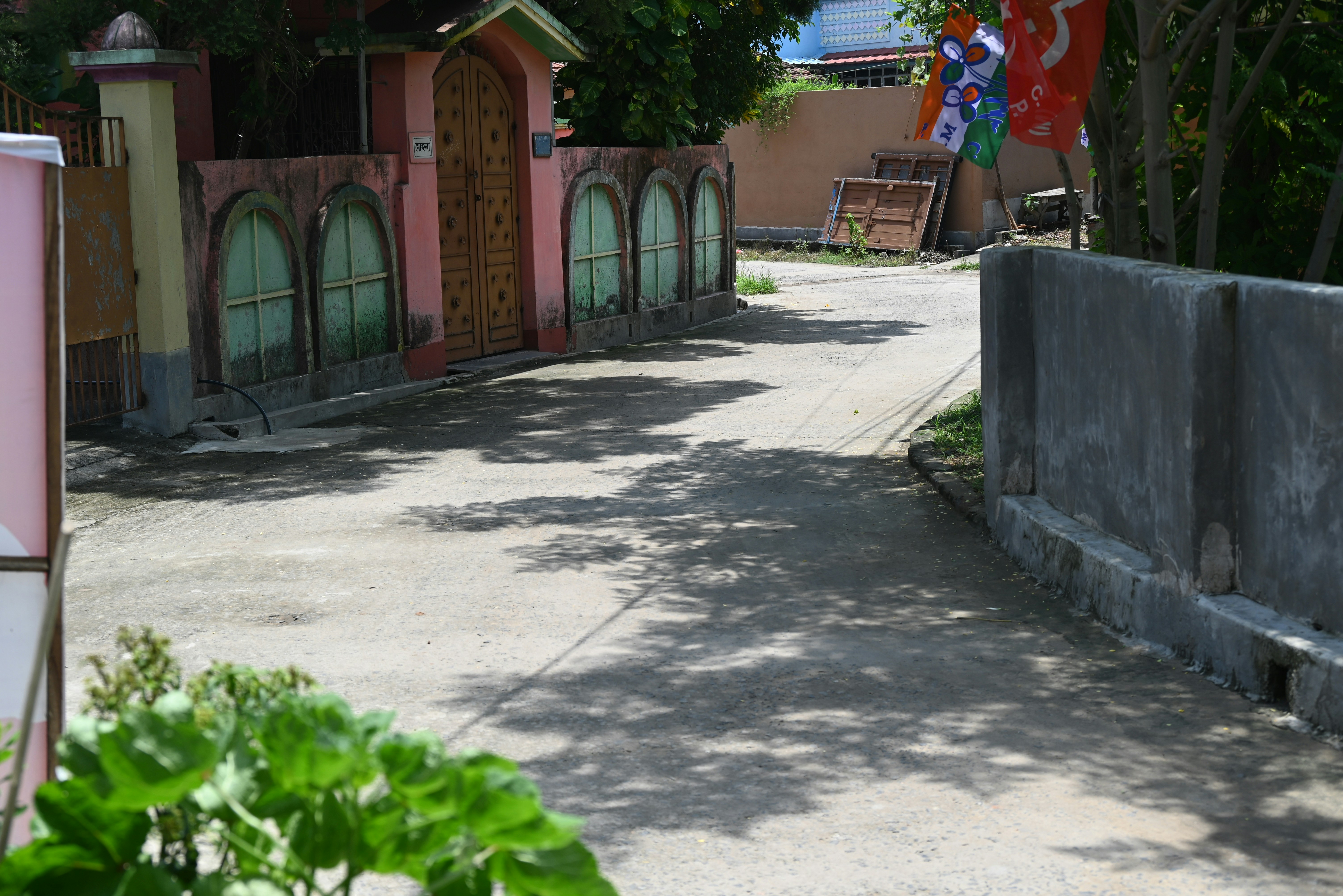 a street with a fence and a building in the background