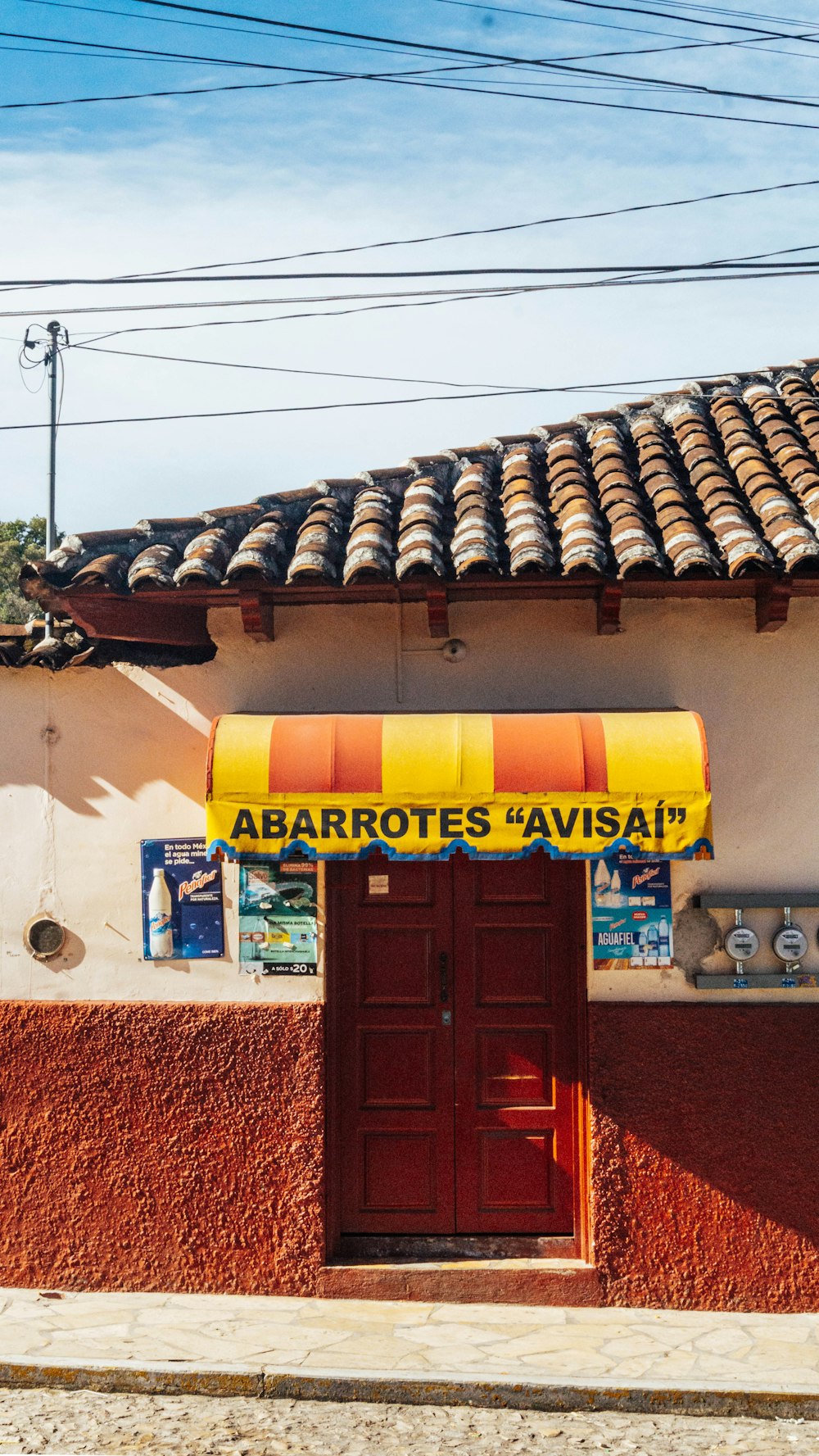 a building with a yellow awning and a red door