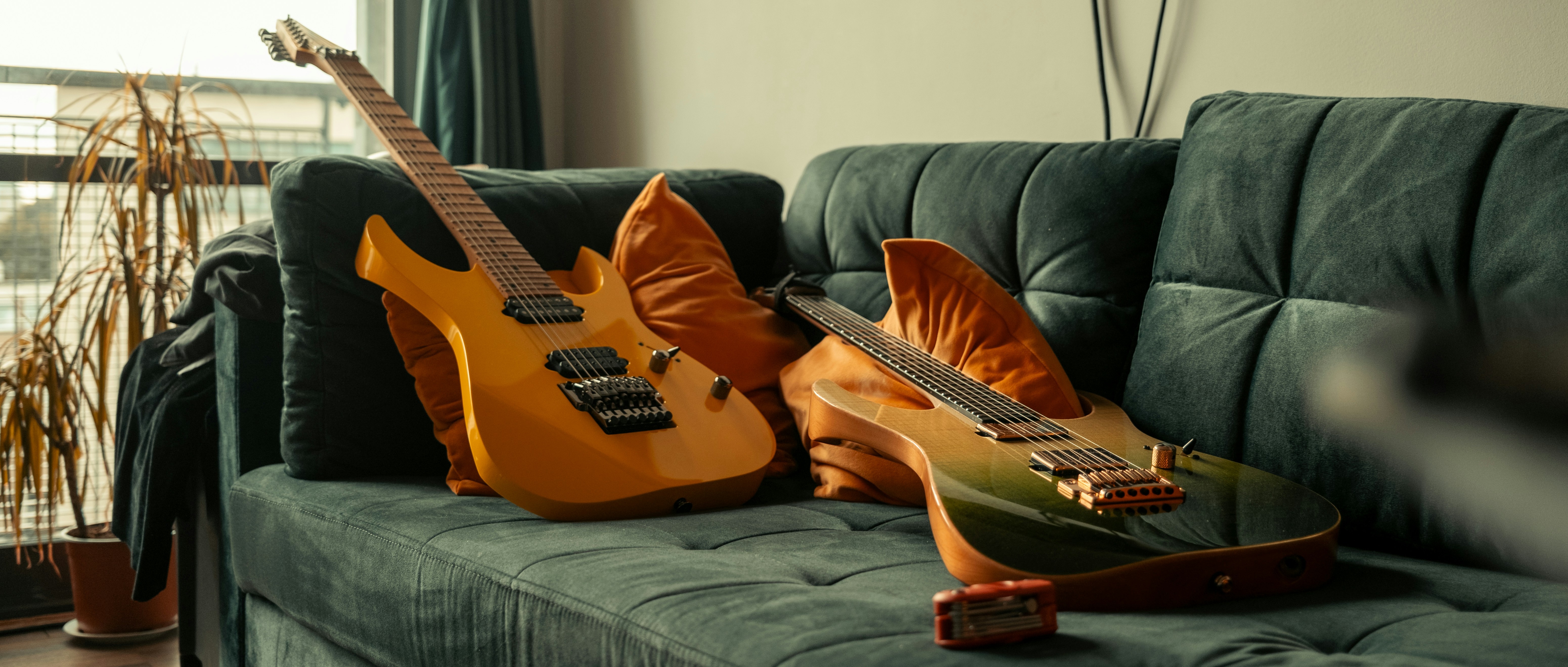 two guitars sitting on a couch in a living room