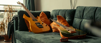 two guitars sitting on a couch in a living room
