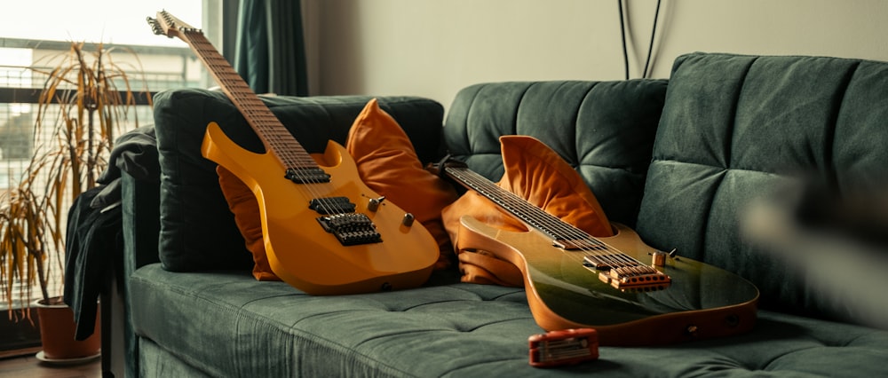 two guitars sitting on a couch in a living room