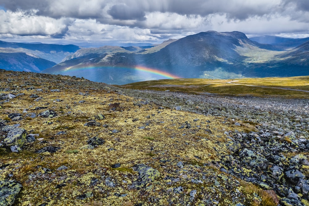 a rainbow in the sky over a mountain range