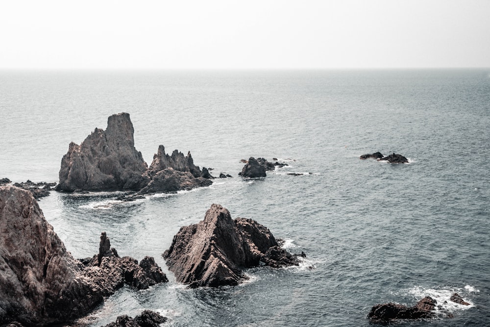 a group of rocks in the middle of a body of water