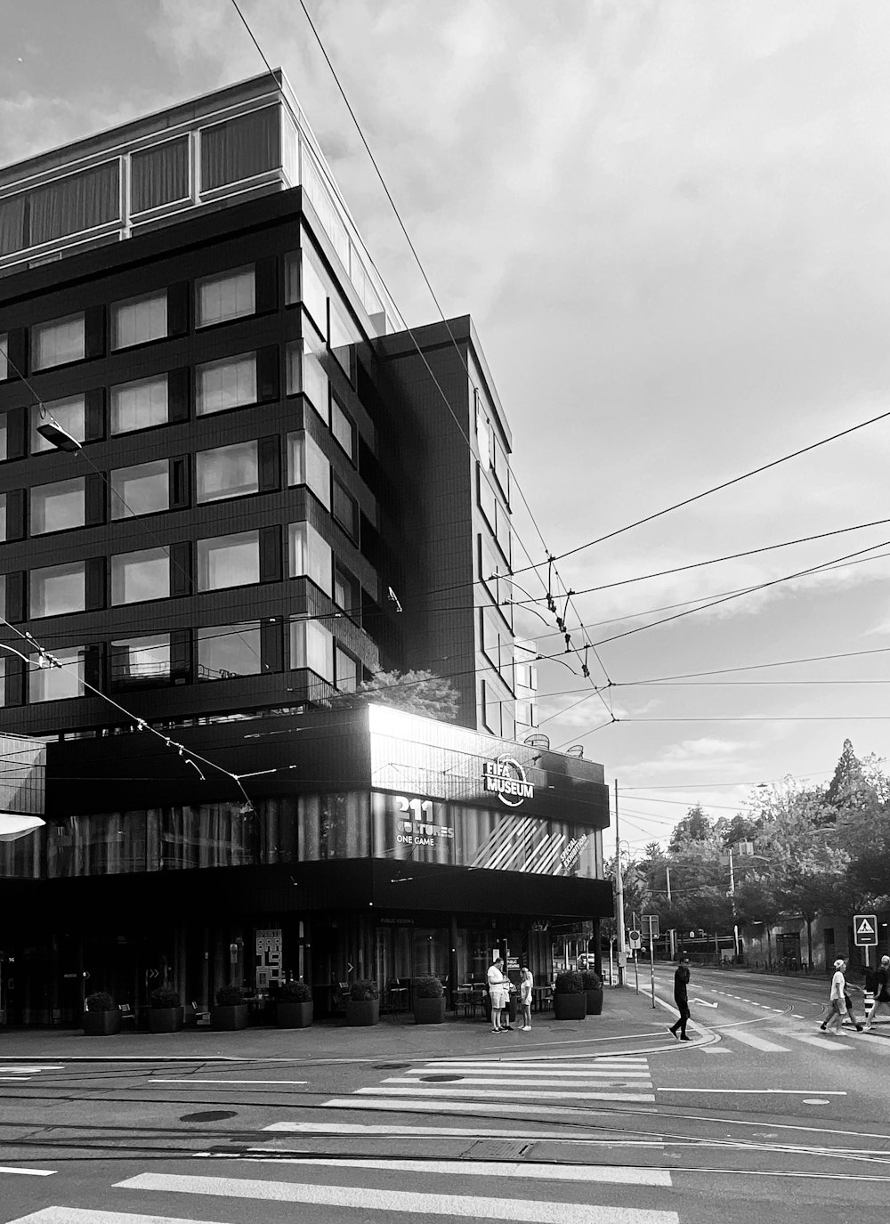 a black and white photo of people crossing the street