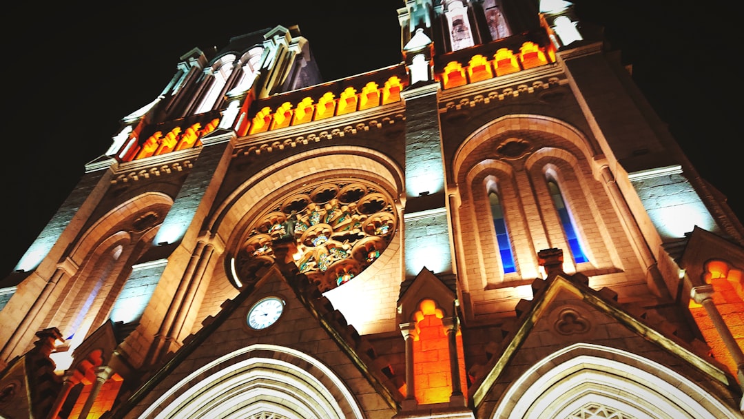 a large cathedral lit up at night with a clock,