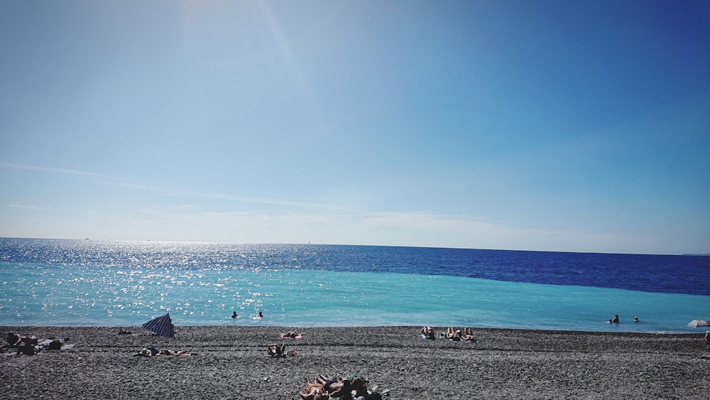 a group of people sitting on top of a beach next to the ocean