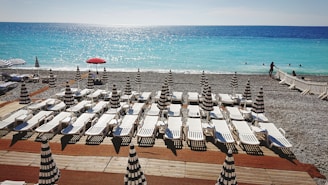 A vibrant beach club with sun loungers and umbrellas.