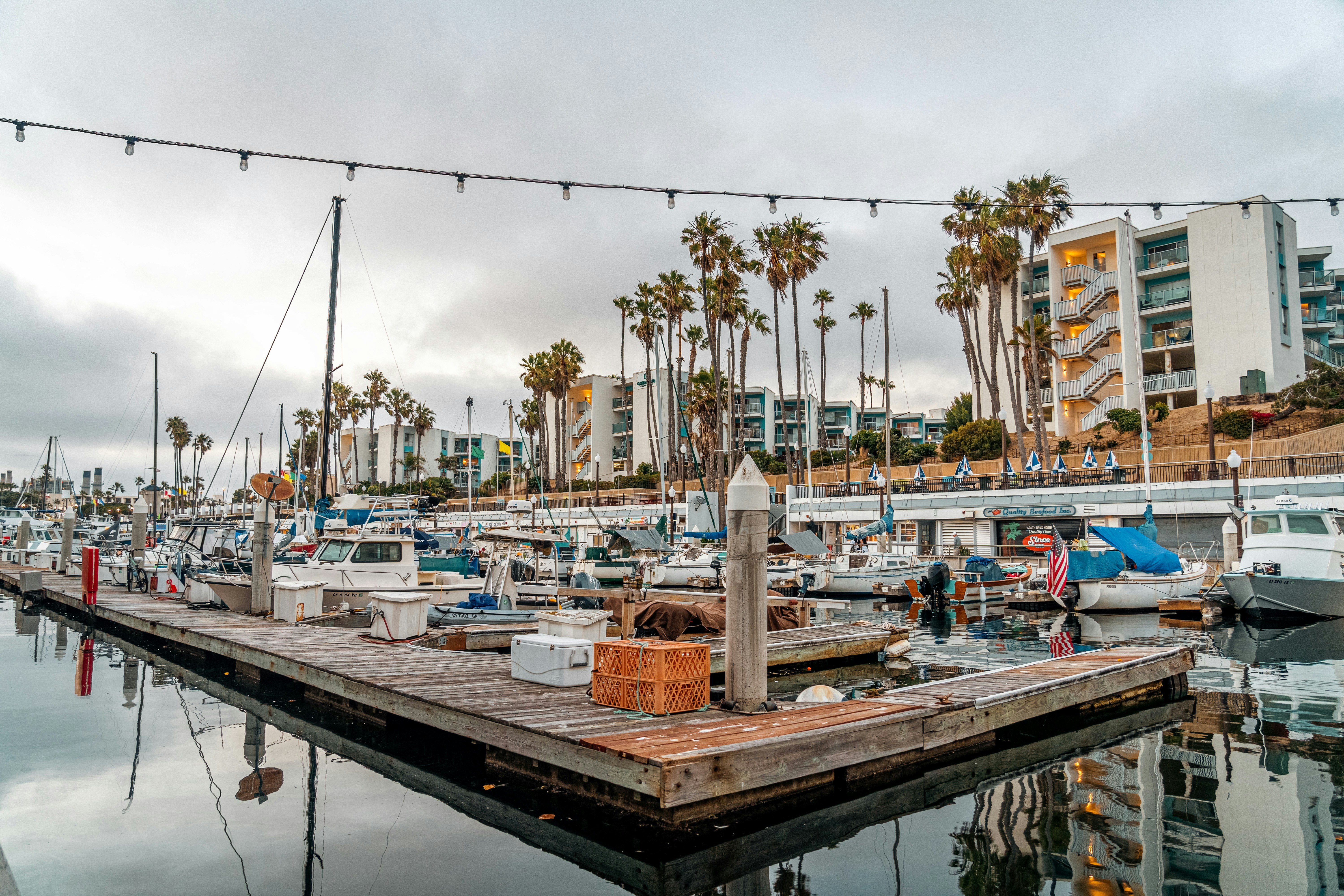 A marina filled with lots of boats under a cloudy sky