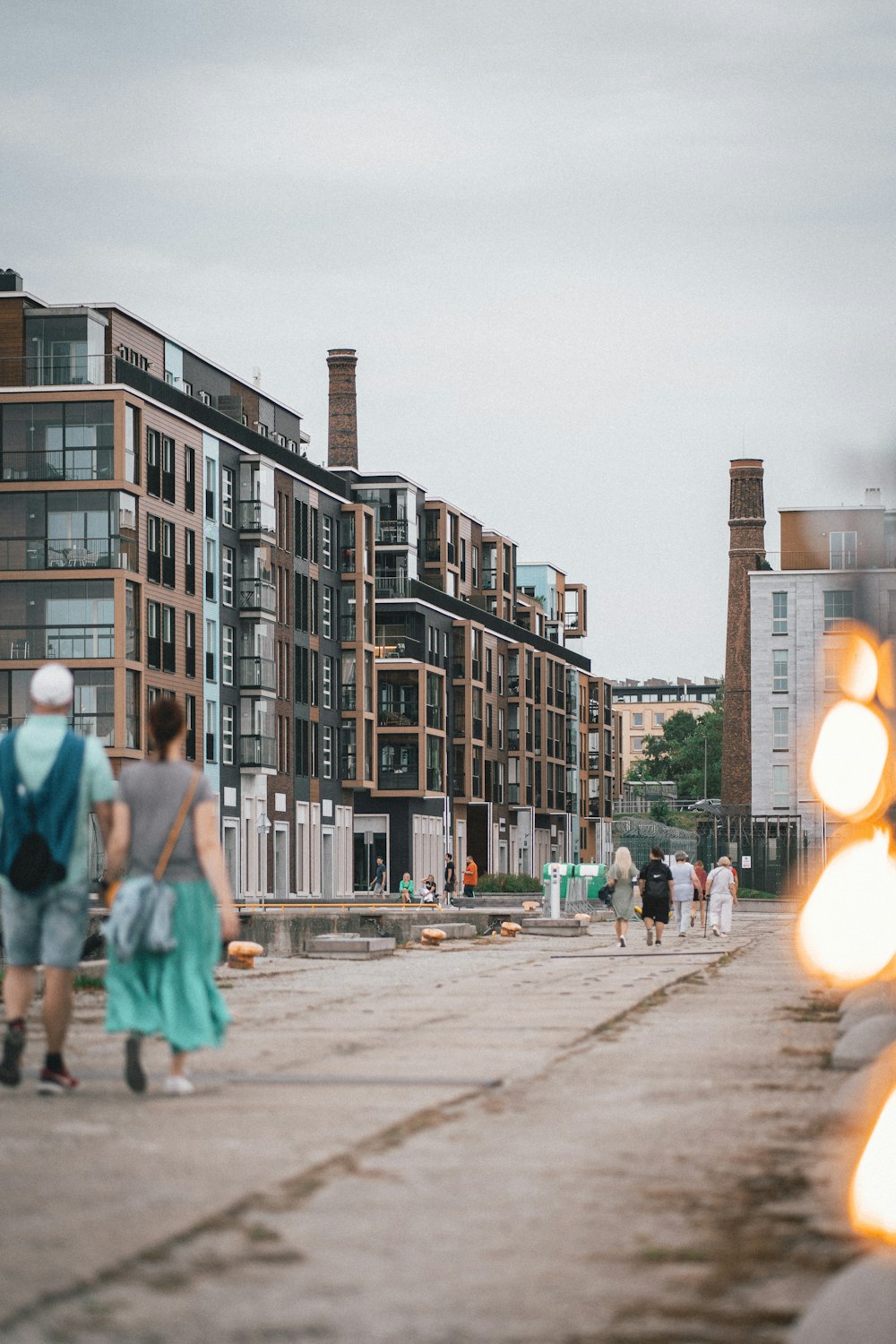 a group of people walking down a street next to tall buildings