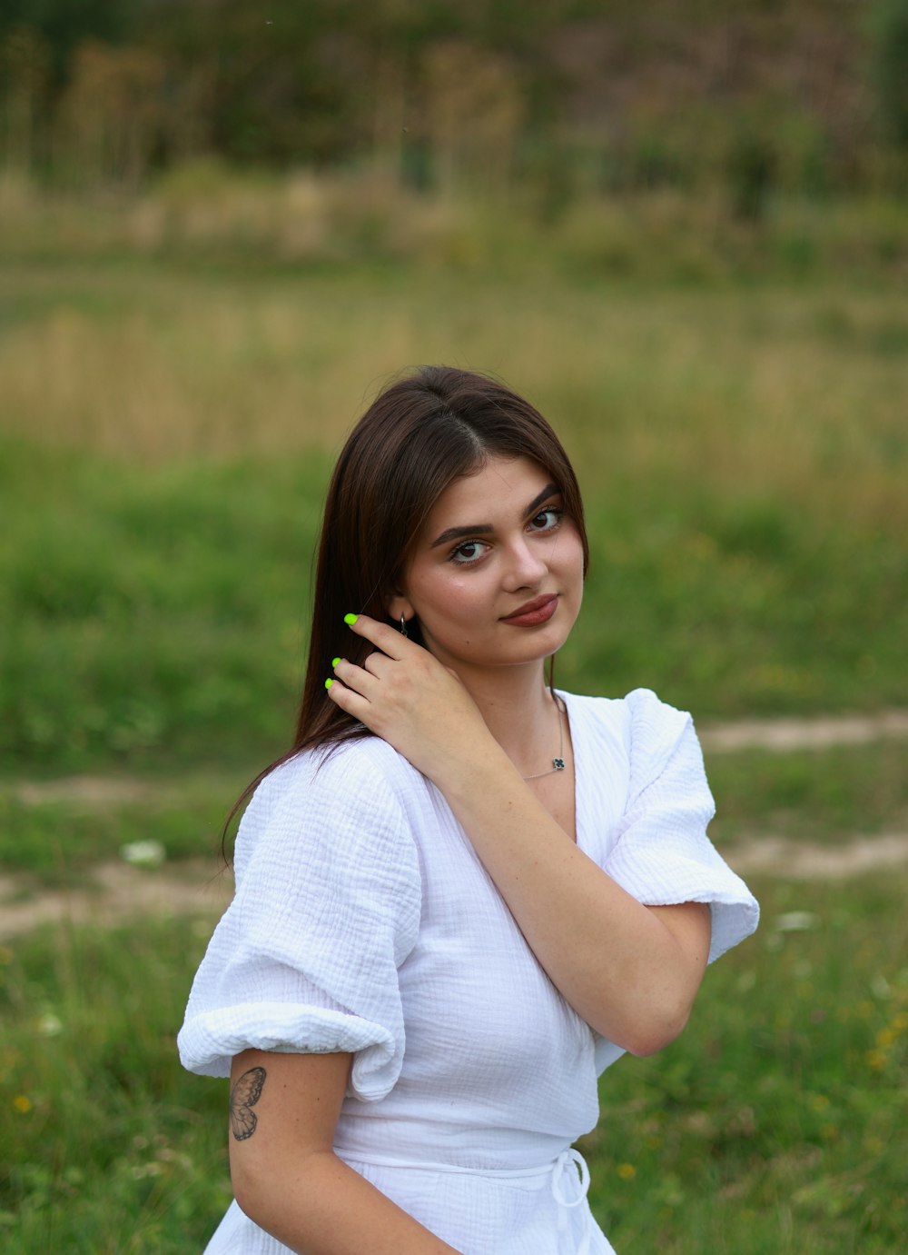 a woman in a white dress talking on a cell phone