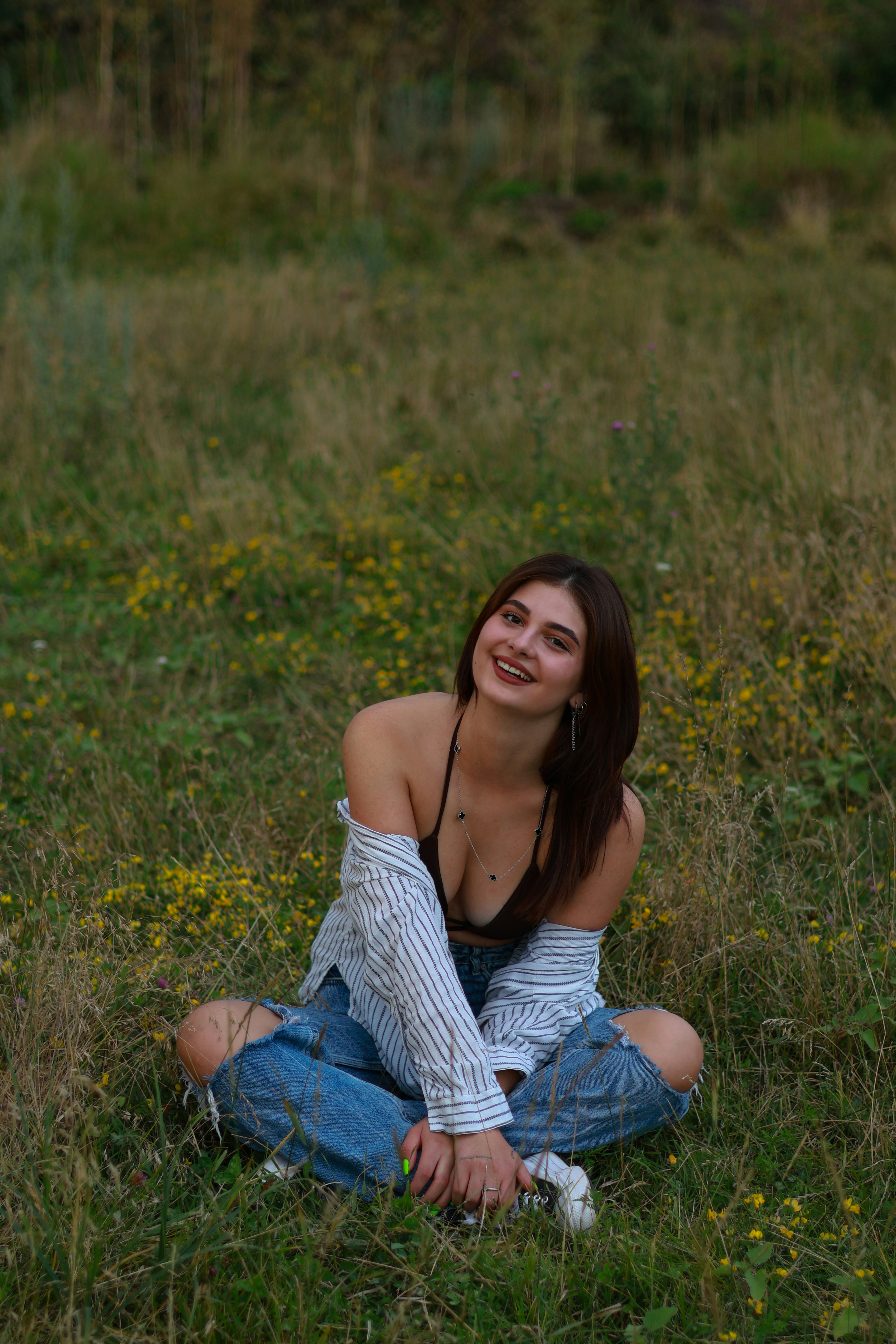 a woman sitting on the ground in a field