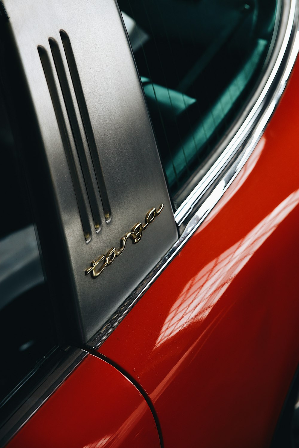 a close up of a car's emblem on a red car