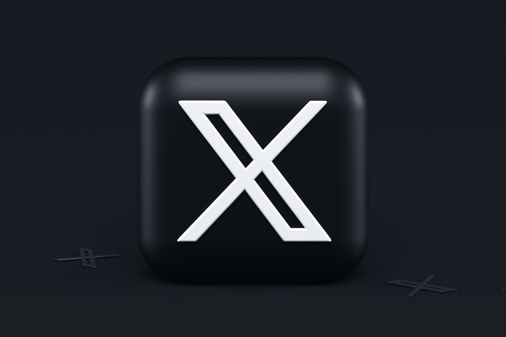 ein schwarzer quadratischer Knopf mit einem weißen X darauf