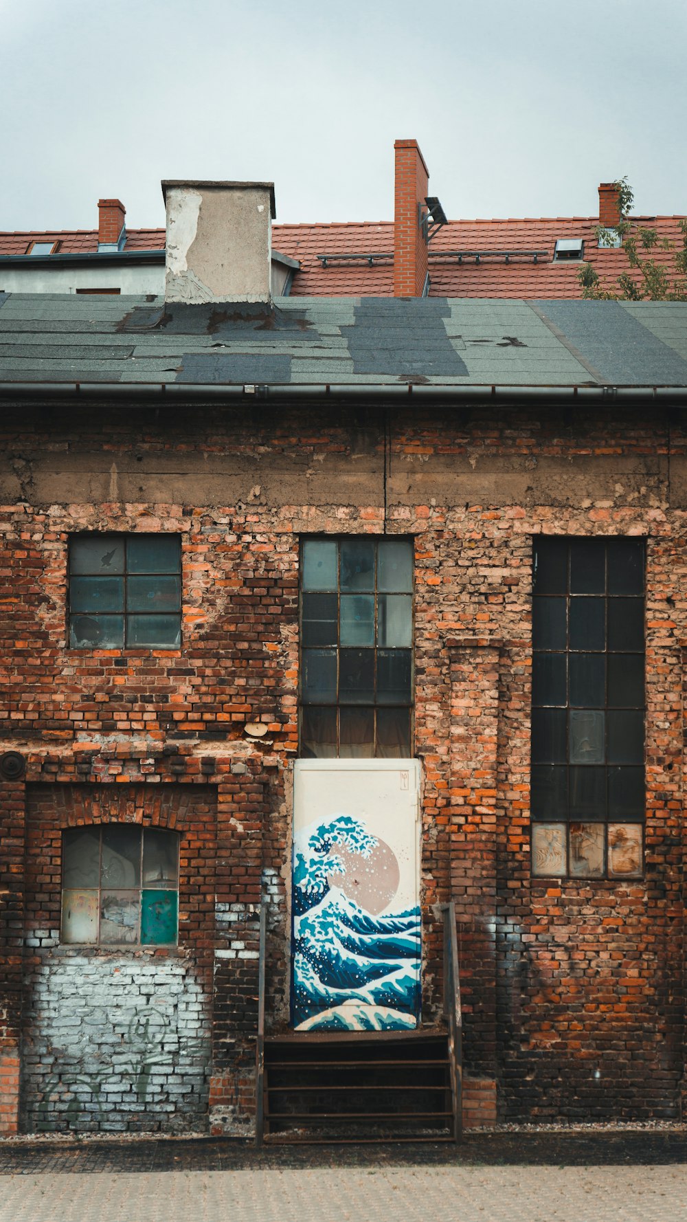 a brick building with a painting of a wave on it