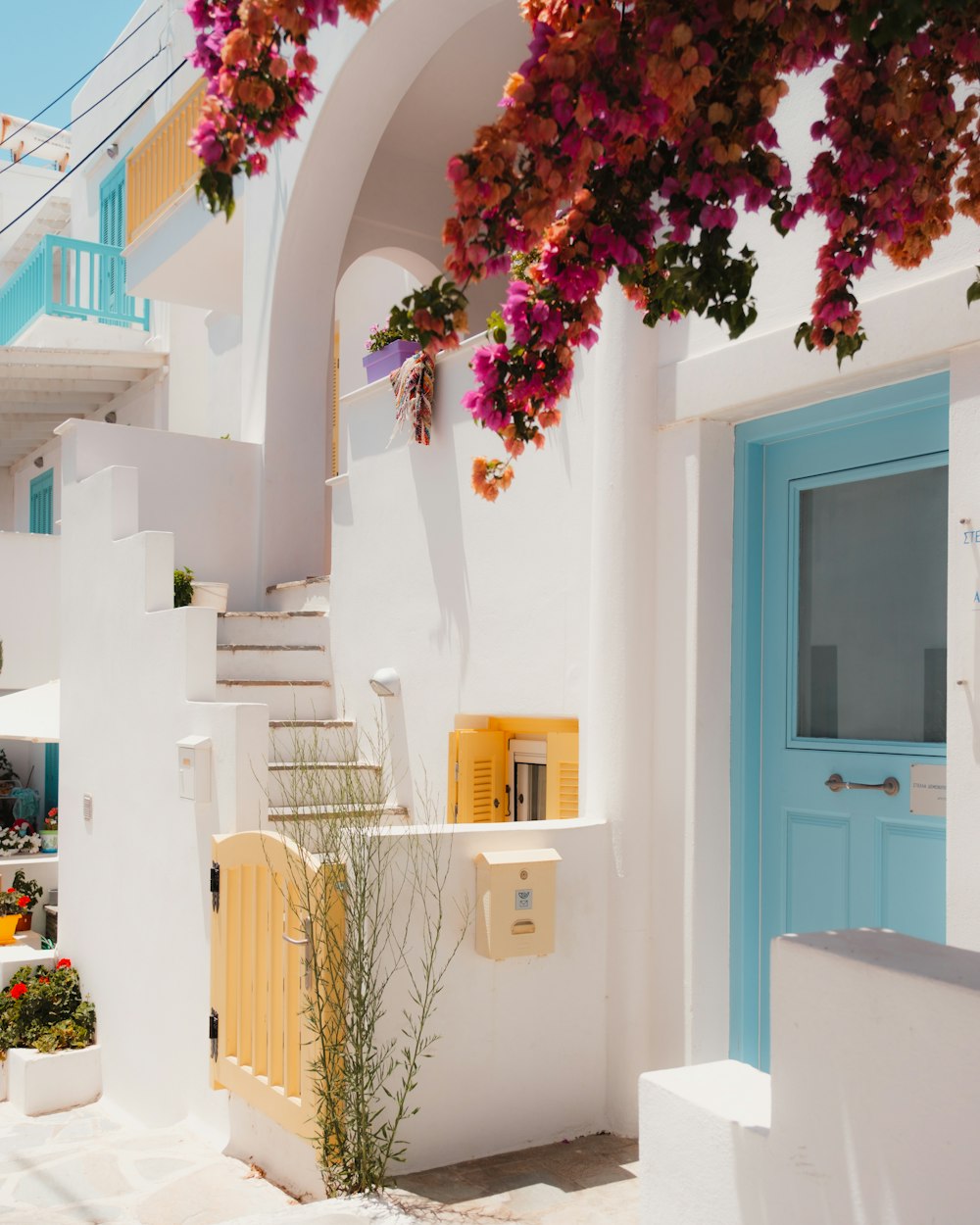 Una casa bianca con una porta blu e scale