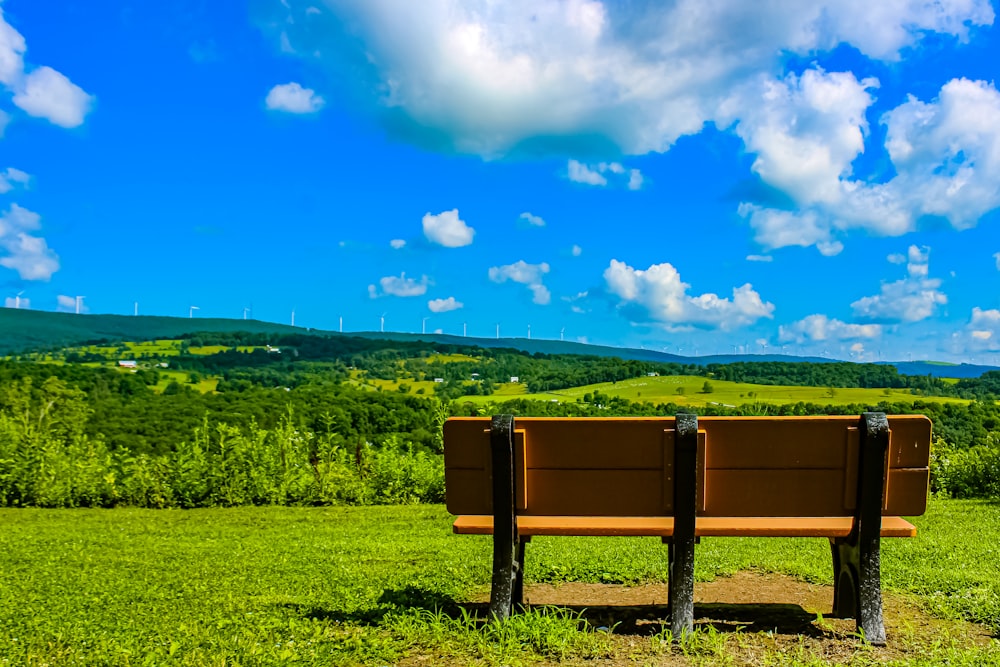 a wooden bench sitting on top of a lush green field