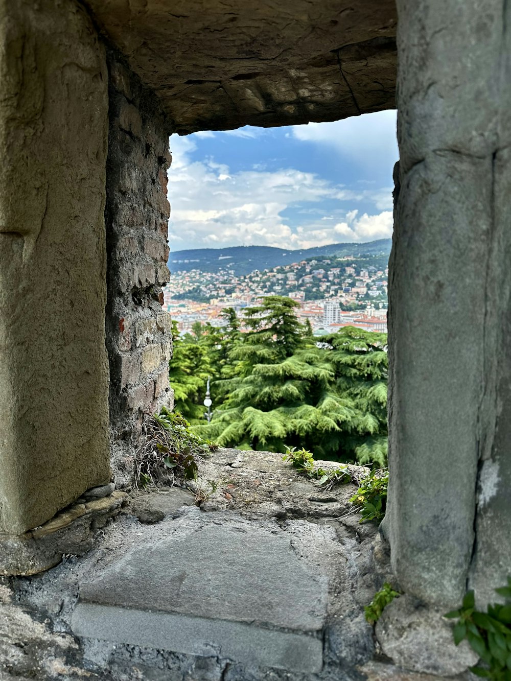 an open window with a view of a city in the distance