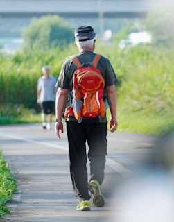 a man walking down a road with a backpack on his back