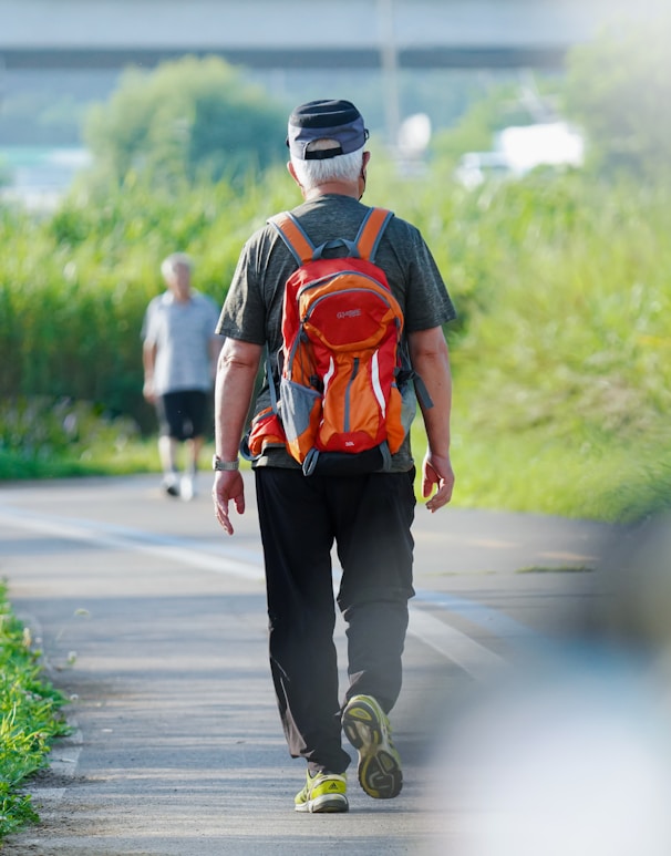 a man walking down a road with a backpack on his back