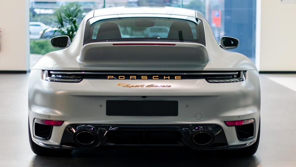 a white porsche sports car parked in a garage