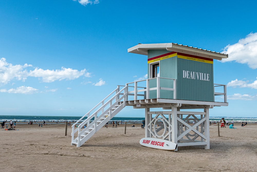 a lifeguard tower on the beach with a life guard sign