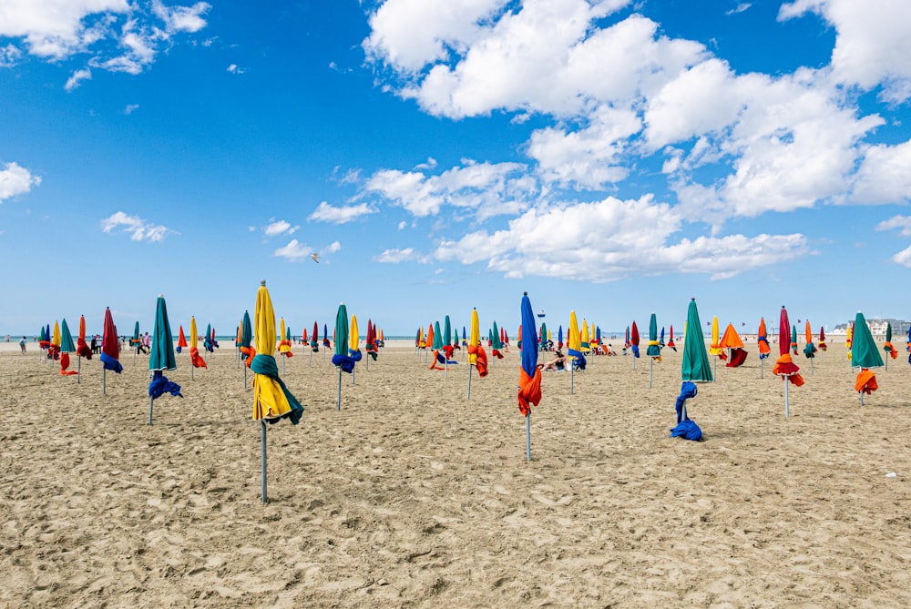 a bunch of umbrellas that are in the sand