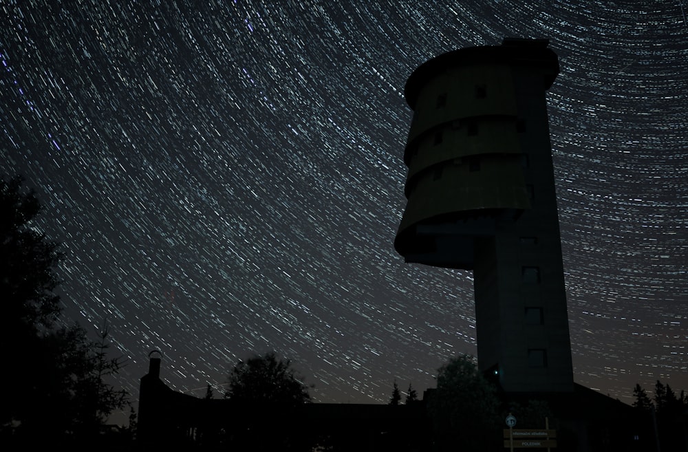 a tower with a star trail in the sky