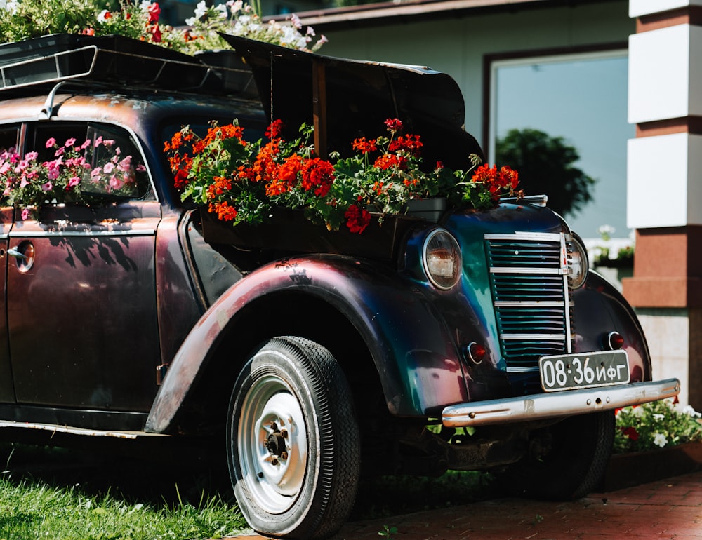 an old car with flowers growing out of it