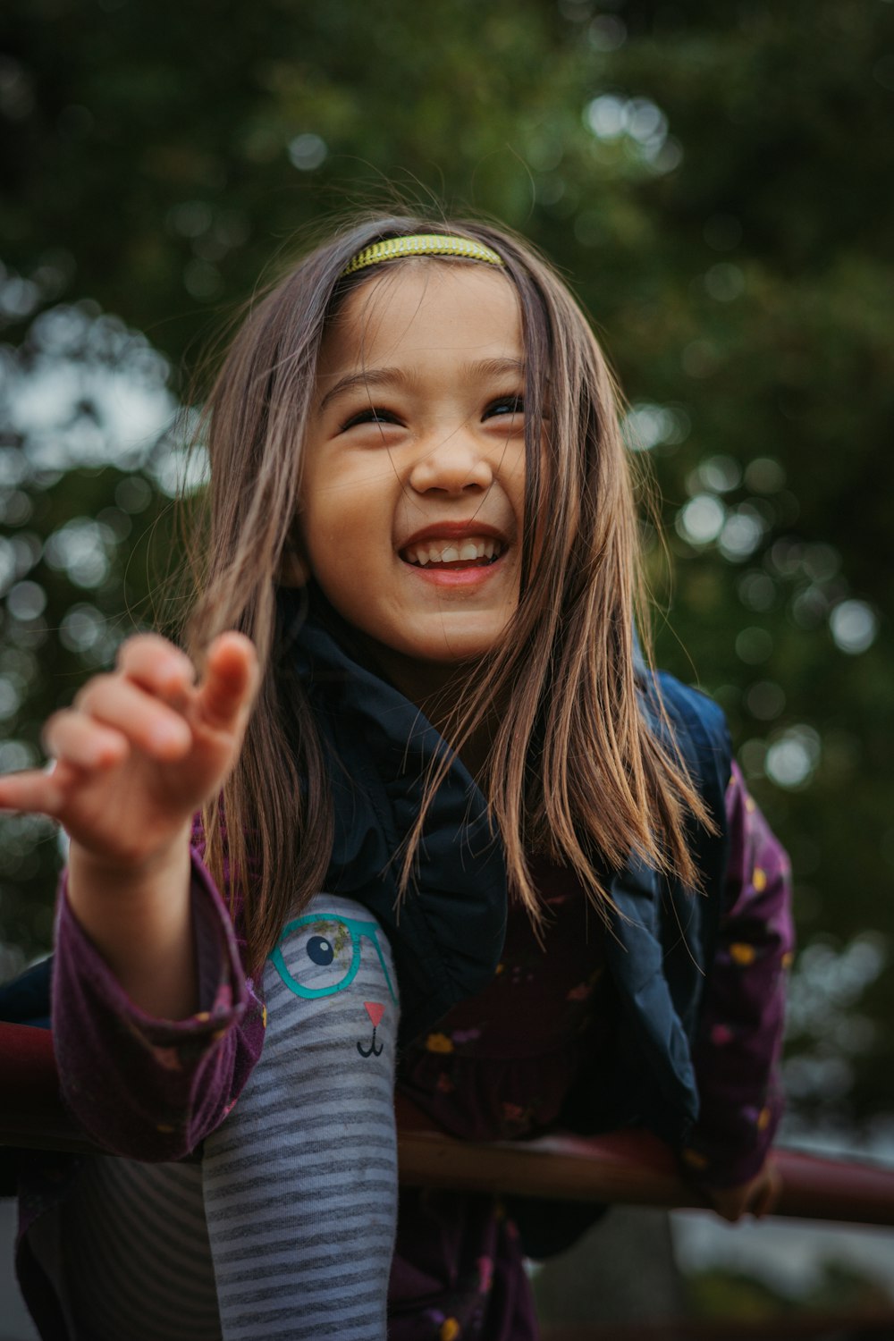 a young girl smiles and holds her hand out