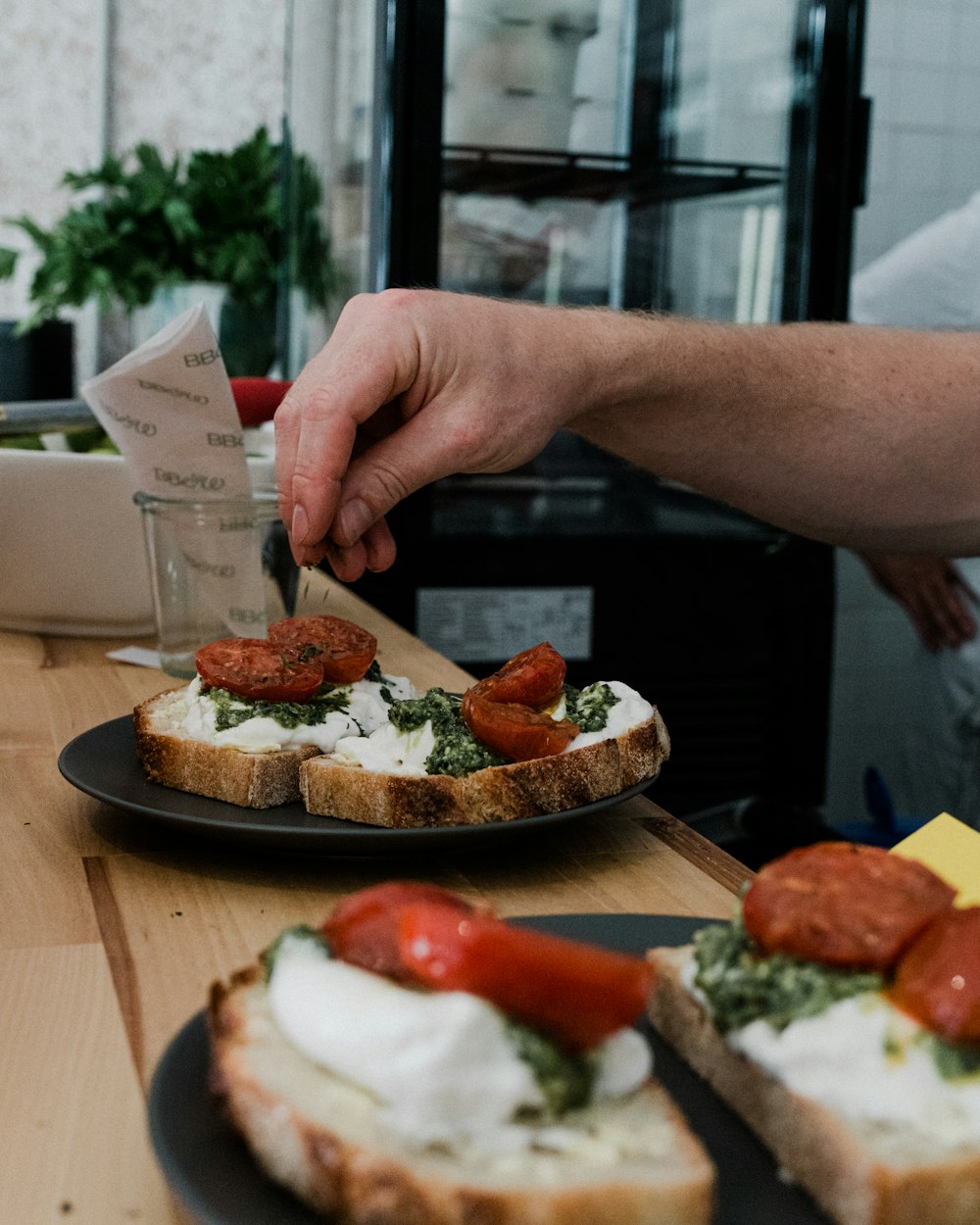 a person cutting a piece of bread with a knife