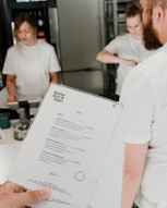 a person holding a menu in a kitchen