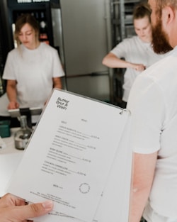 a person holding a menu in a kitchen