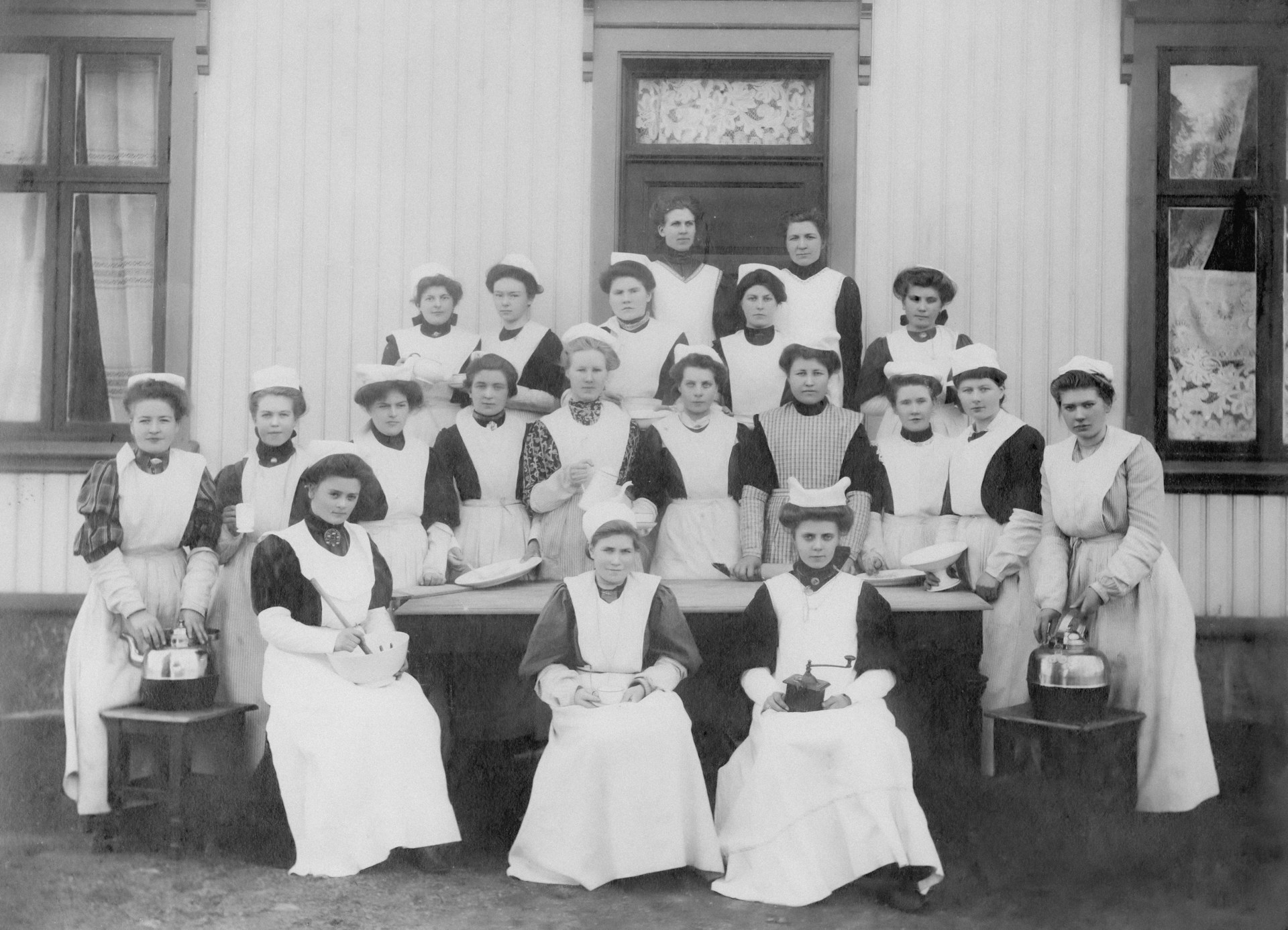 a group of women in aprons posing for a picture