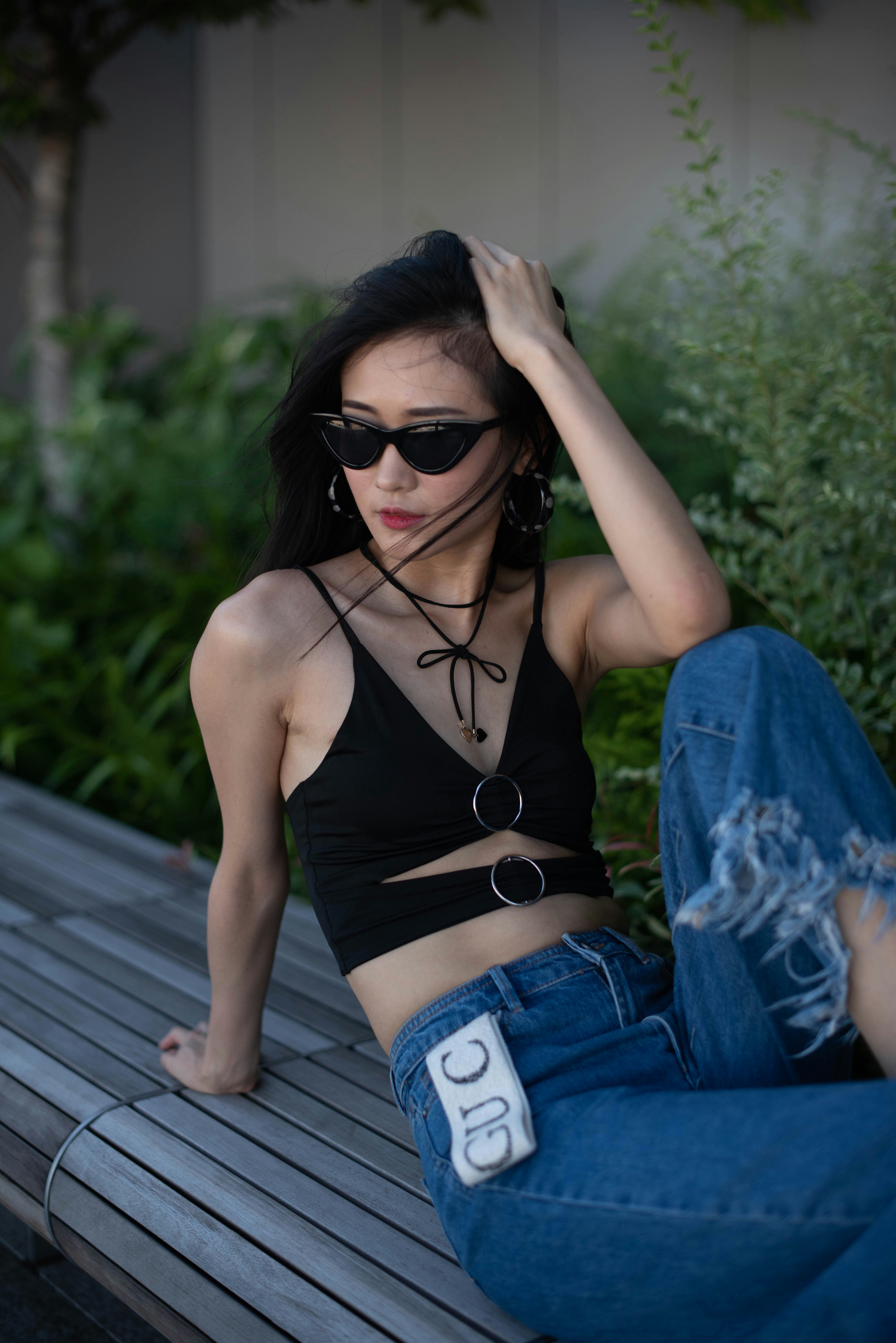 a woman sitting on top of a wooden bench