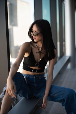 Model gazing out a window, wearing a stylish trench coat paired with relaxed jeans.