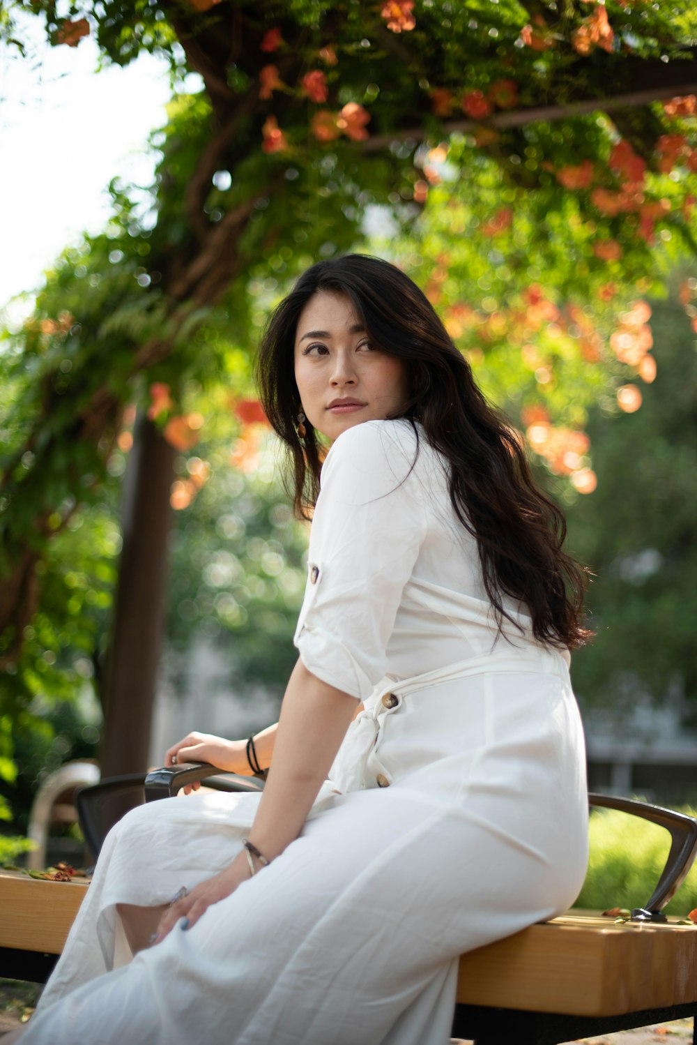 a woman in a white dress sitting on a bench