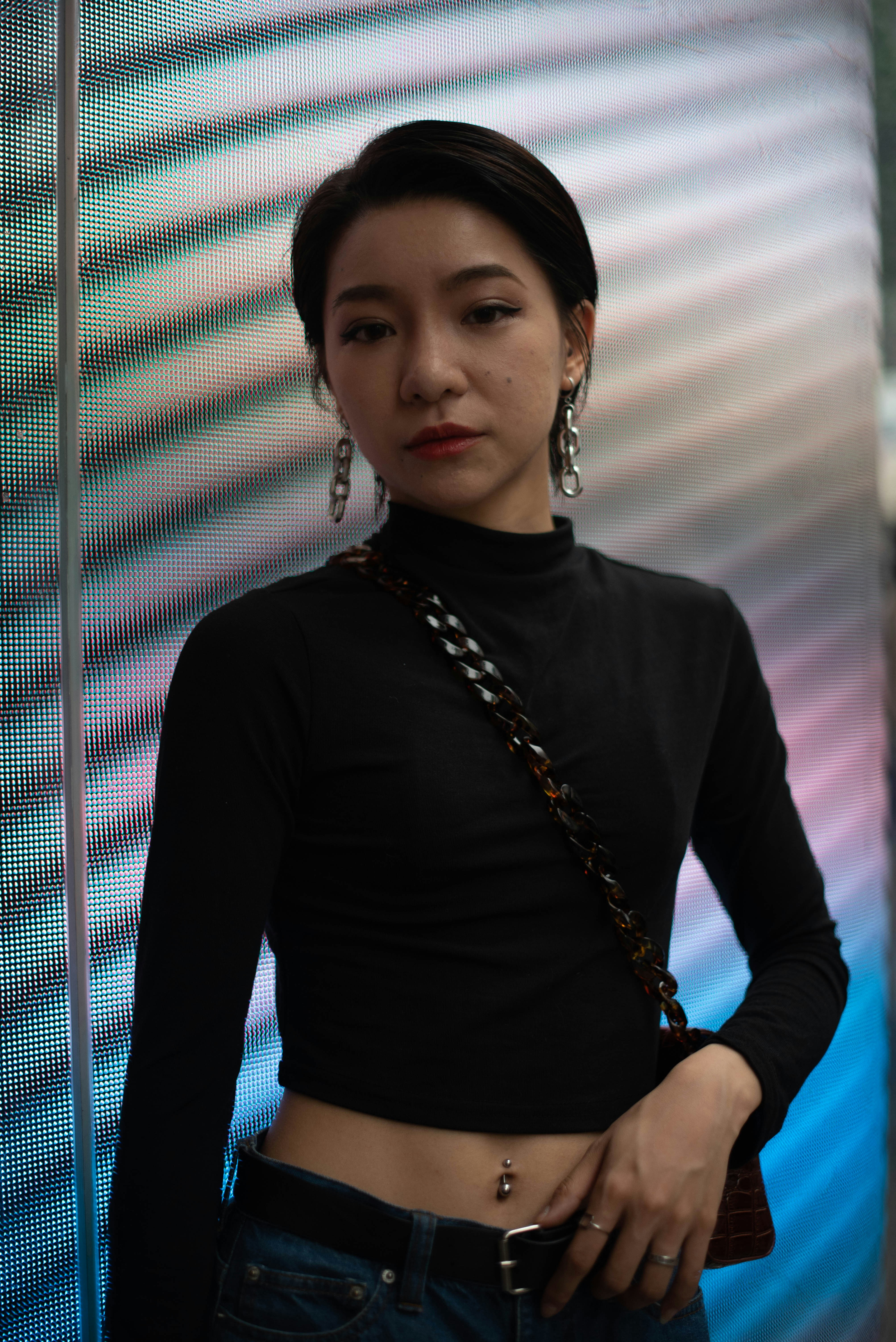 A woman standing in front of a wall wearing a black top photo – Free ...