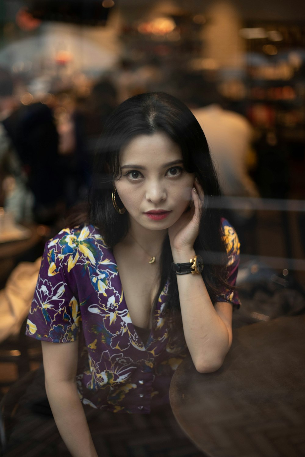 a woman sitting at a table with her hand on her face