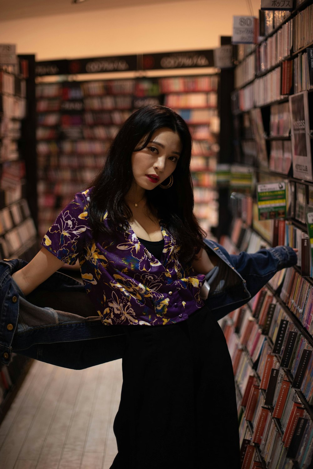 a woman standing in front of a book shelf