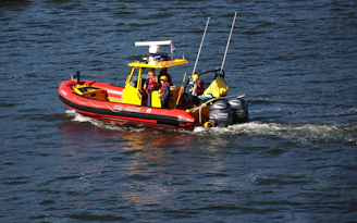 A red and yellow boat traveling down a river
