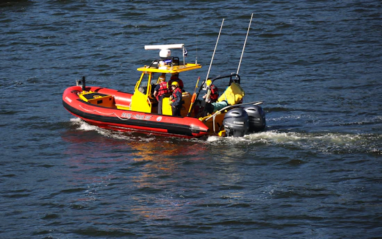 A red and yellow boat traveling down a river